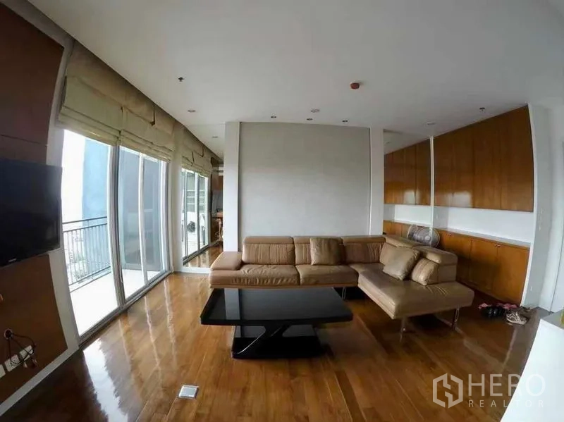 Condominium for rent or sale in Khlong San, Bangkok - Bright living area with floor-to-ceiling glass and built-in cabinetry.
