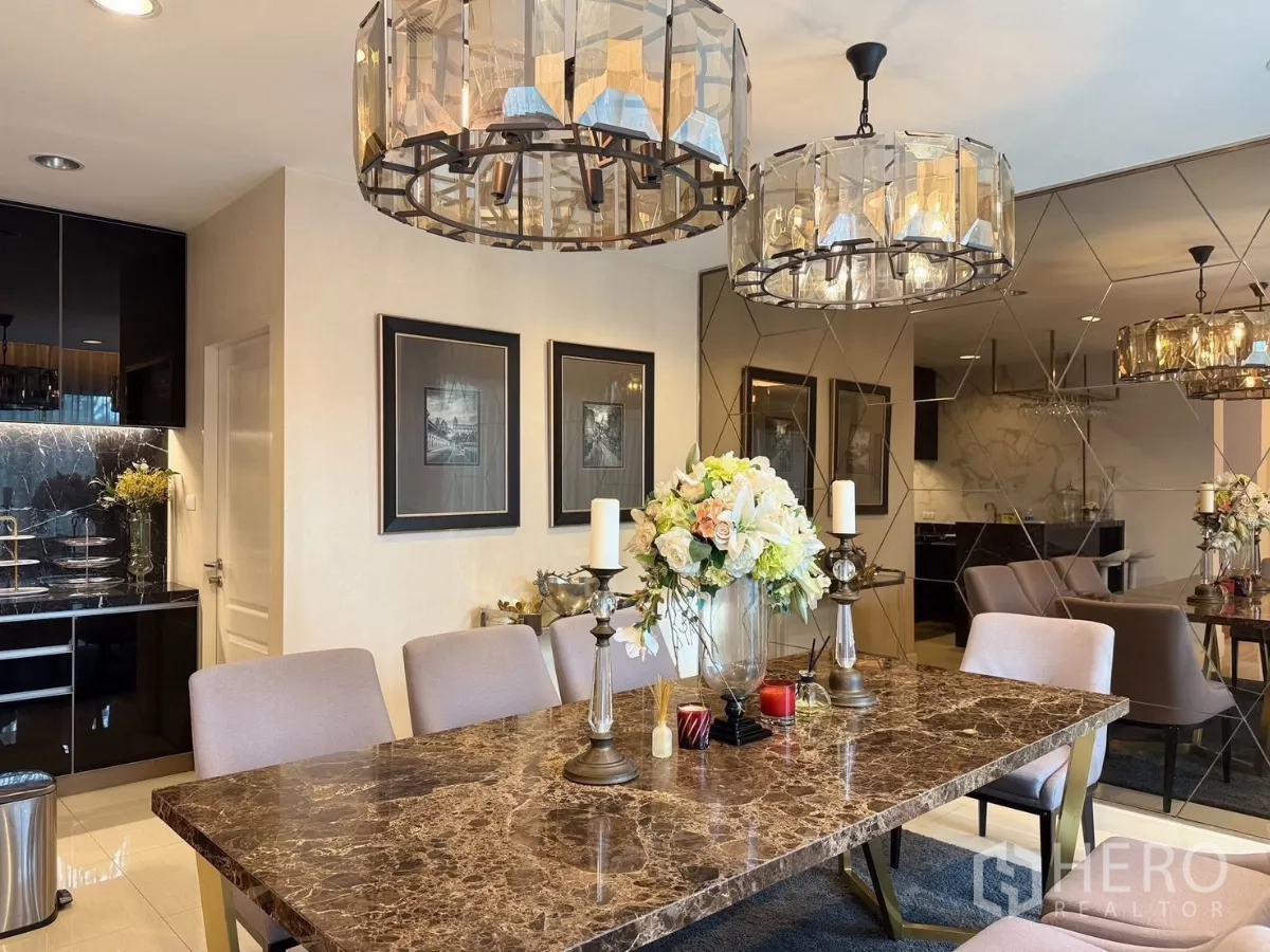 Detached House for rent or sale in Prawet, Bangkok - Dining area adjacent to a mirrored wall and sleek black pantry kitchen.