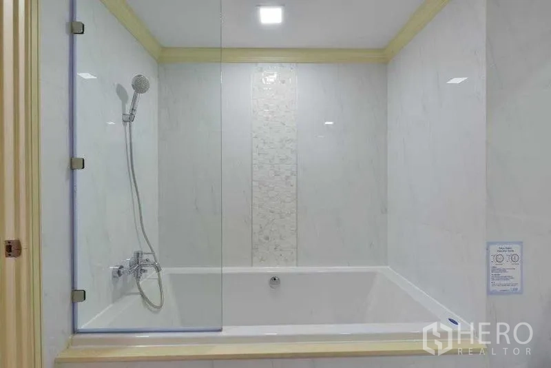 房间 出租在Khlong Toei, Bangkok - 浴缸特写，手持花洒与透明玻璃隔断。