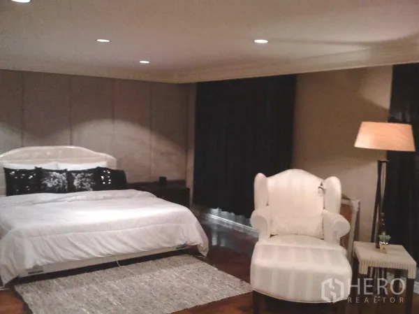 ทาวน์เฮาส์ ให้เช่าในKhlong Toei, Bangkok - ห้องนอนใหญ่กว้างพร้อมเตียงคิง โซฟาอาร์มแชร์ โคมไฟยืน และผ้าม่านทึบ