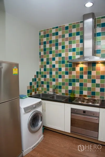 คอนโด ให้เช่าในKhlong Toei, Bangkok - ครัวขนาดกะทัดรัด ผนังโมเสกสีสันสดใส เครื่องดูดควัน ตู้เย็น และเครื่องซักผ้า