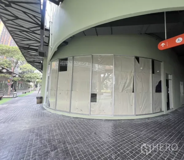 零售空间 出租在Suan Luang, Bangkok - 位于曼谷Suan Luang的转角商铺外立面，弧形落地玻璃与有顶步行街。