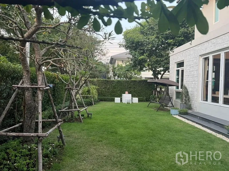 บ้าน ขายในPrawet, Bangkok - สวนหลังบ้านกว้าง พร้อมแนวรั้วต้นไม้และมุมที่นั่งพักผ่อน