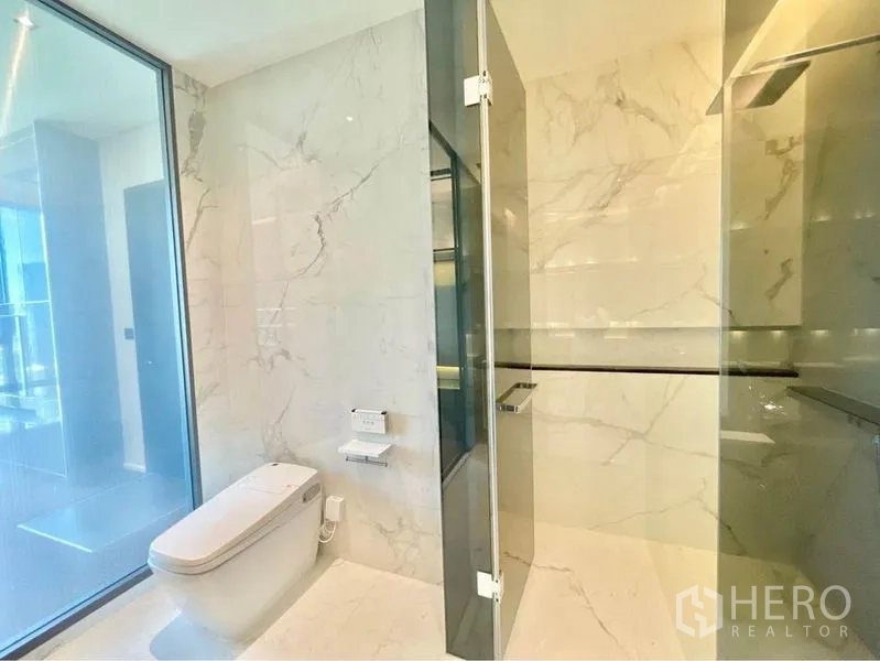 Condominium for rent in Watthana, Bangkok - Bright marble bathroom featuring glass walk-in shower and modern fixtures.
