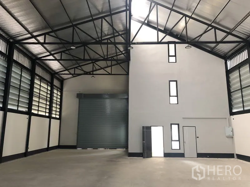 โรงงาน ขายในThanyaburi, Pathum Thani - พื้นที่โกดังภายใน เพดานสูงประมาณ 8 ม. โครงหลังคาเหล็กและประตูม้วนใหญ่