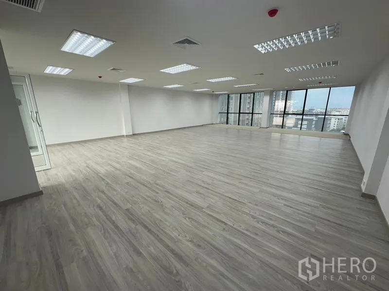 Office Space for rent - Corner office area with panoramic glazing, ceiling air-conditioning vents and a glass entry door