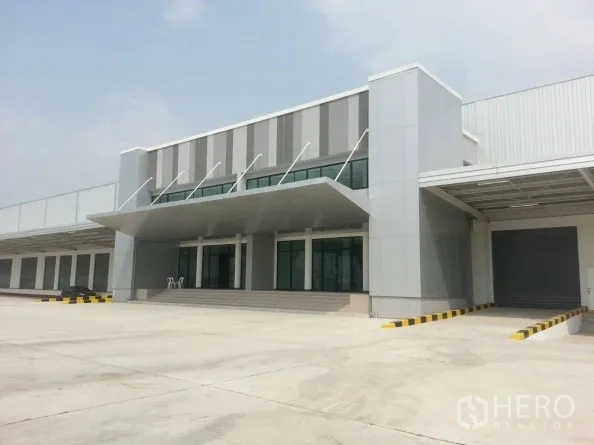 คลังสินค้า ให้เช่าในBang Sao Thong, Samut Prakan - อาคารสำนักงานหน้าโกดังแบบโมเดิร์น กระจกบานใหญ่ ประตูม้วนท่าโหลด และลานรถบรรทุกกว้าง