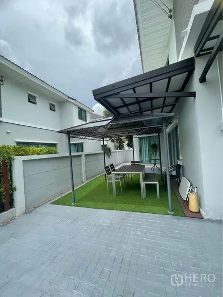 บ้าน ขายในLat Krabang, Bangkok - ลานข้างบ้านพร้อมหลังคา ศาลานั่งเล่น ชุดโต๊ะเก้าอี้ และสนามหญ้าเทียม