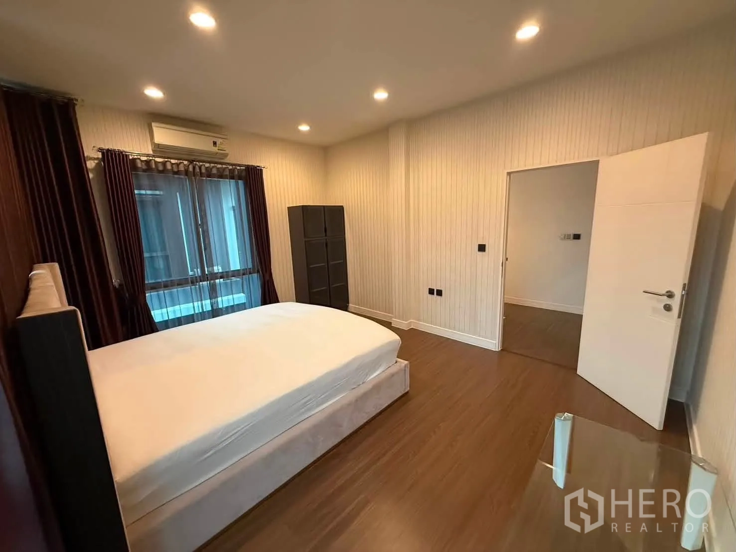 独栋房屋 for rent in Bang Kapi, Bangkok - 卧室配软包床、窗帘、木地板与空调。