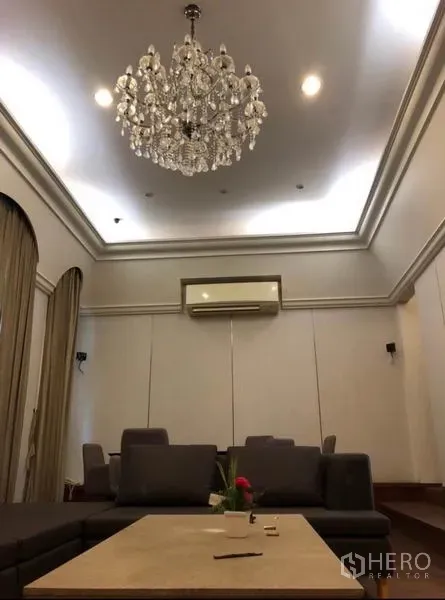 ทาวน์เฮาส์ ให้เช่าในChatuchak, Bangkok - โถงนั่งเล่นเพดานสูงพร้อมโคมระย้า ไฟดาวน์ไลท์ และเครื่องปรับอากาศติดผนัง