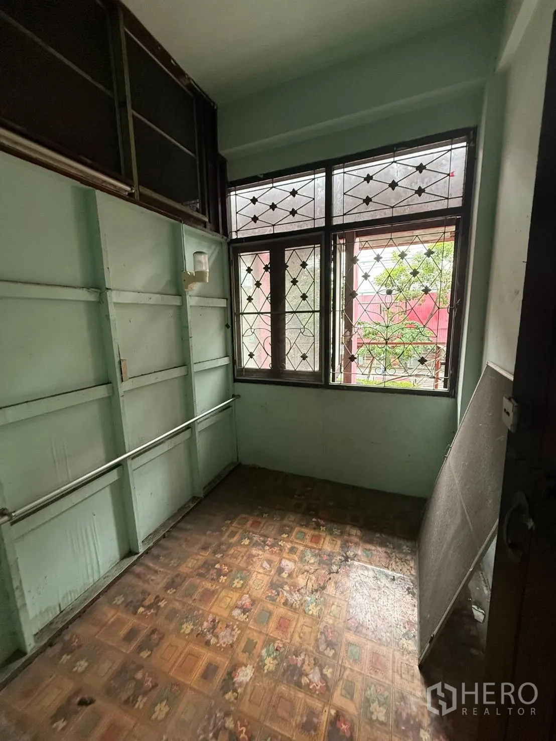 店屋 for rent in Khlong Toei, Bangkok - 小房间，浅绿色墙面、花纹地板和带栅格的窗户。