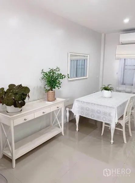ทาวน์เฮาส์ ให้เช่าในPrawet, Bangkok - มุมทานอาหารอบอุ่น โต๊ะสีขาว ตู้คอนโซล ไม้ประดับ และมู่ลี่หน้าต่าง