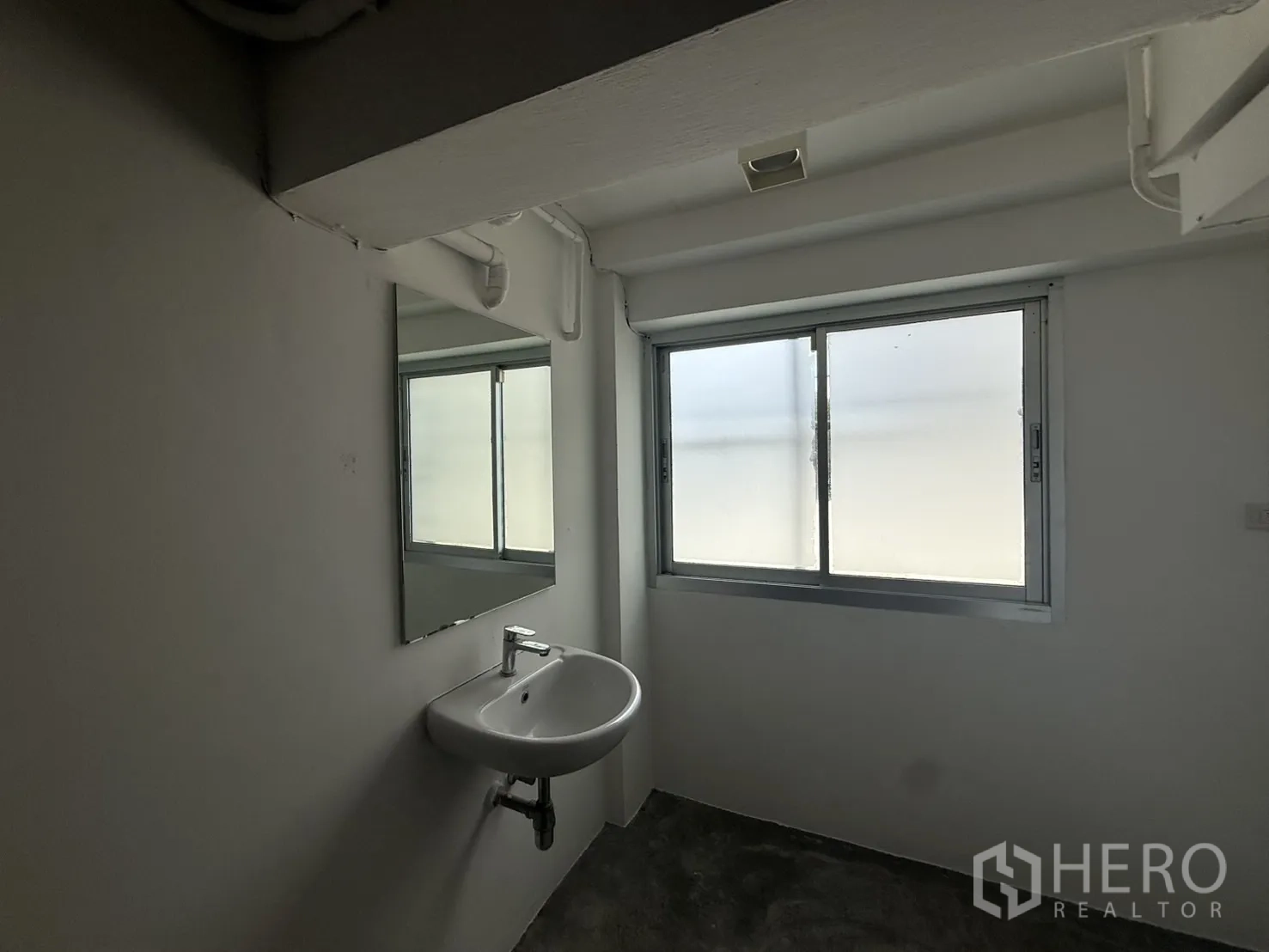 店屋 出租在Wang Thonglang, Bangkok - 洗手区，墙挂式面盆与磨砂推拉窗。