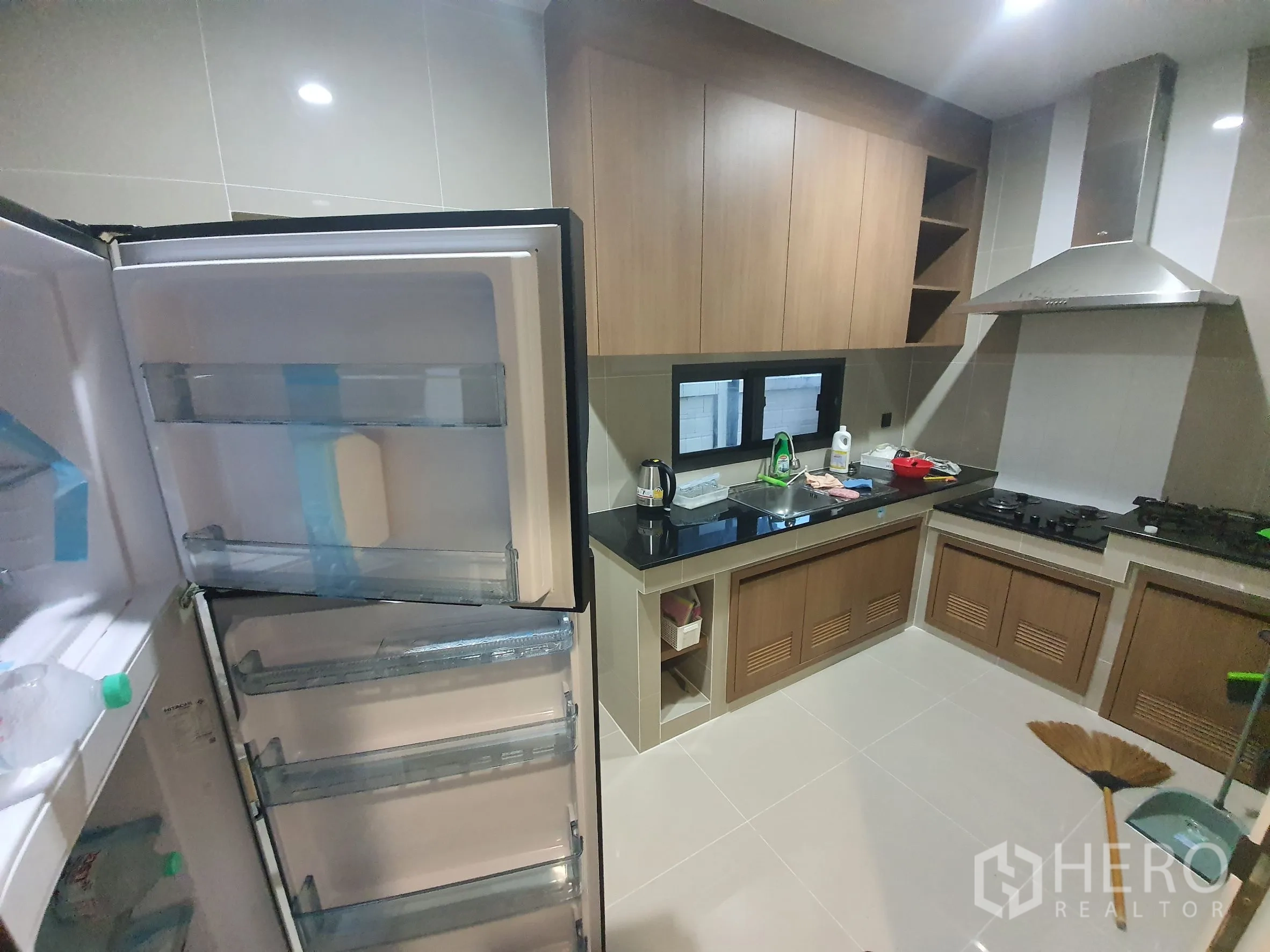 บ้าน ให้เช่าในBang Kapi, Bangkok - ครัวปิดรูปตัวแอล ตู้ไม้ เคาน์เตอร์สีดำ เตาและเครื่องดูดควัน