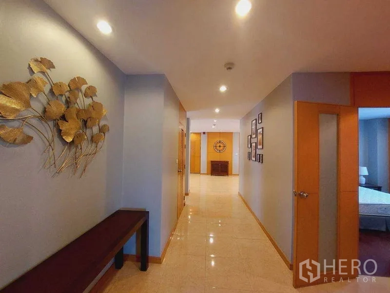 房间 出租 - 走廊设筒灯，金色墙饰与亮面瓷砖地面。