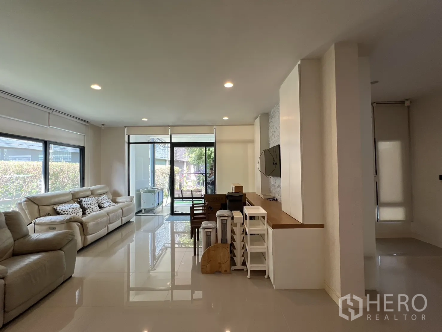 独立式住宅 出售在Bang Kapi, Bangkok - 采光充足的开放式客厅，大窗与米色沙发。