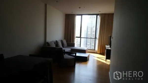 คอนโด ให้เช่าในWatthana, Bangkok - ห้องนั่งเล่นกว้าง โซฟาเข้ามุม พื้นไม้ และหน้าต่างกระจกเต็มผนังมองเห็นวิวสกายไลน์กรุงเทพฯ