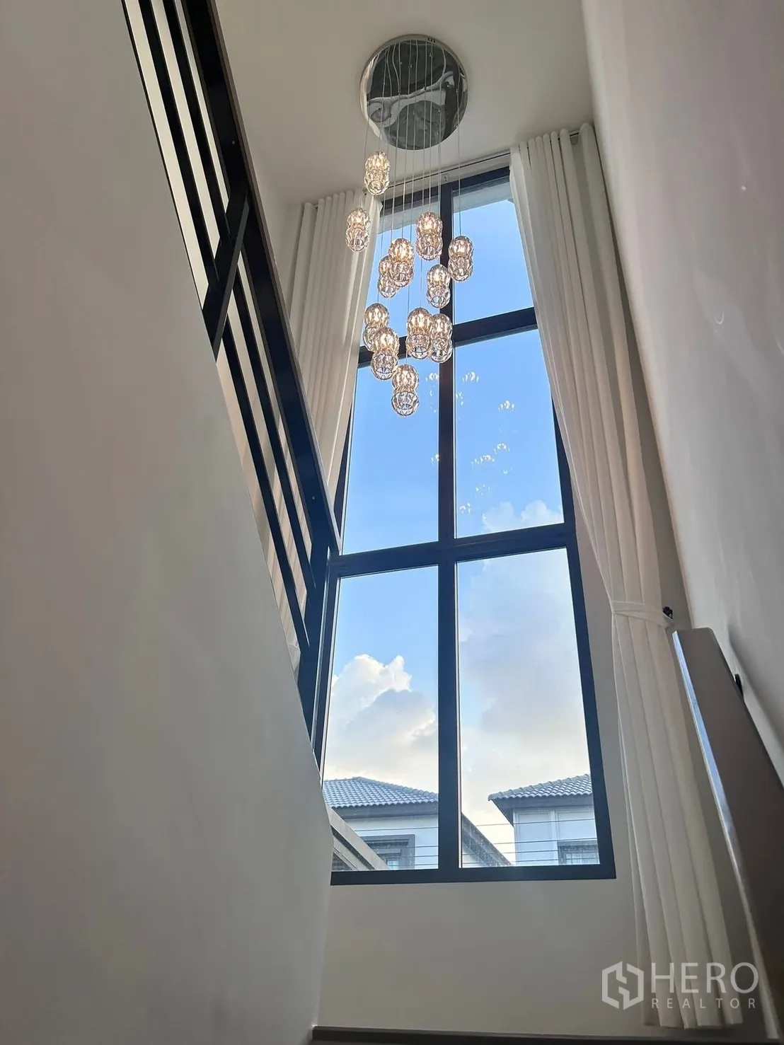 Semi-detached House for rent in Bang Phli, Samut Prakan - Staircase with soaring picture window and hanging crystal pendant lights.