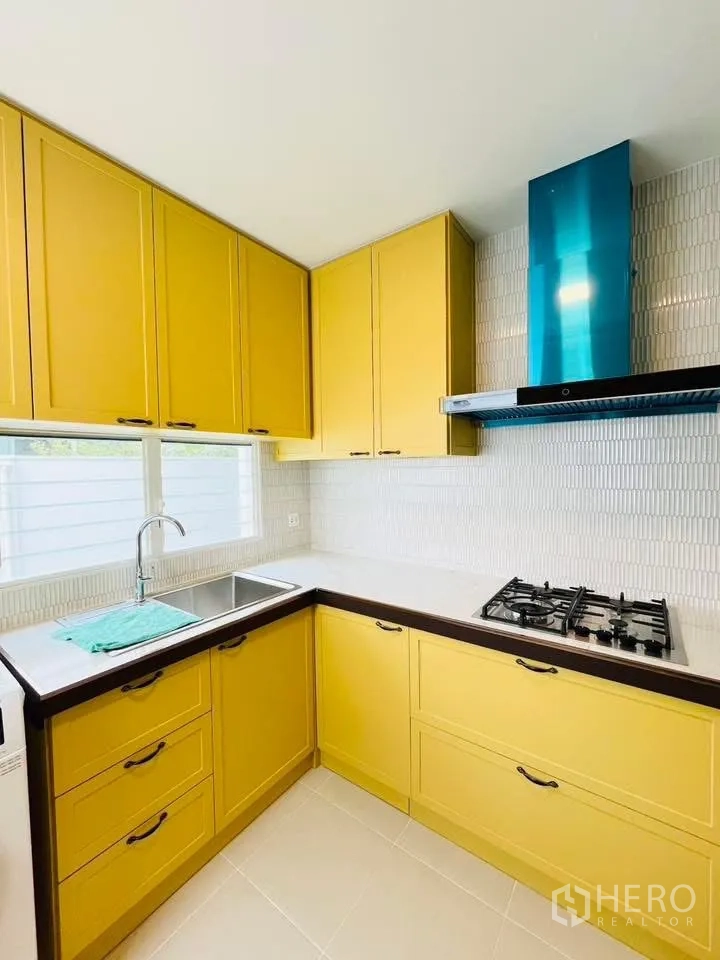 Detached House for rent in Bang Phli, Samut Prakan - Bright kitchen corner with yellow cabinetry, cooktop, and range hood.