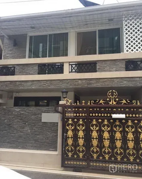 ทาวน์เฮาส์ ให้เช่าในKhlong Toei, Bangkok - ทาวน์เฮาส์สองชั้นในกรุงเทพฯ ด้านหน้าตกแต่งผนังหิน มีระเบียงและประตูเหล็กทองลายหรู