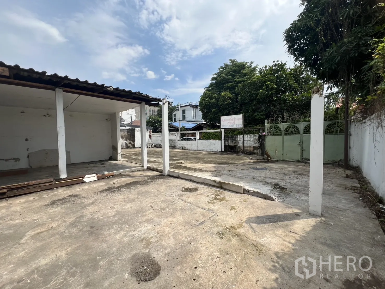 独立式住宅 出租在Phra Khanong, Bangkok - 宽阔的入户车道与庭院，围墙与绿植环绕。