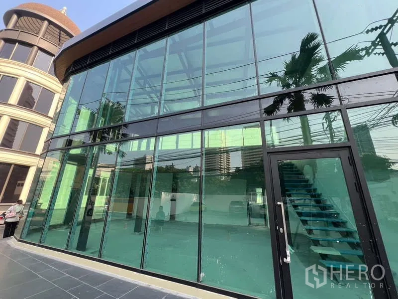 零售空间 出租在Watthana, Bangkok - 临街玻璃店面，入口门及室内楼梯可见