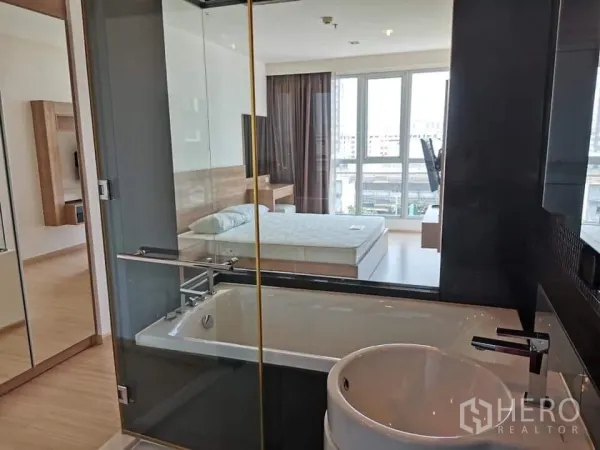 公寓 出租或出售在Khlong Toei, Bangkok - 玻璃隔断浴室带浴缸，可眺望采光充足的卧室与落地窗。