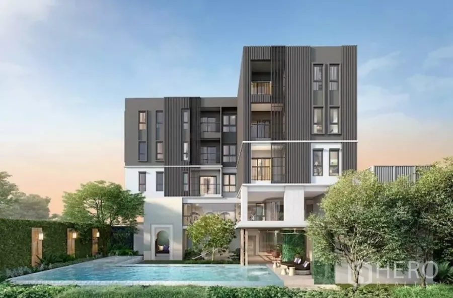 Townhouse for rent in Khlong Toei, Bangkok - Modern low‑rise residence with landscaped swimming pool and greenery at sunset.