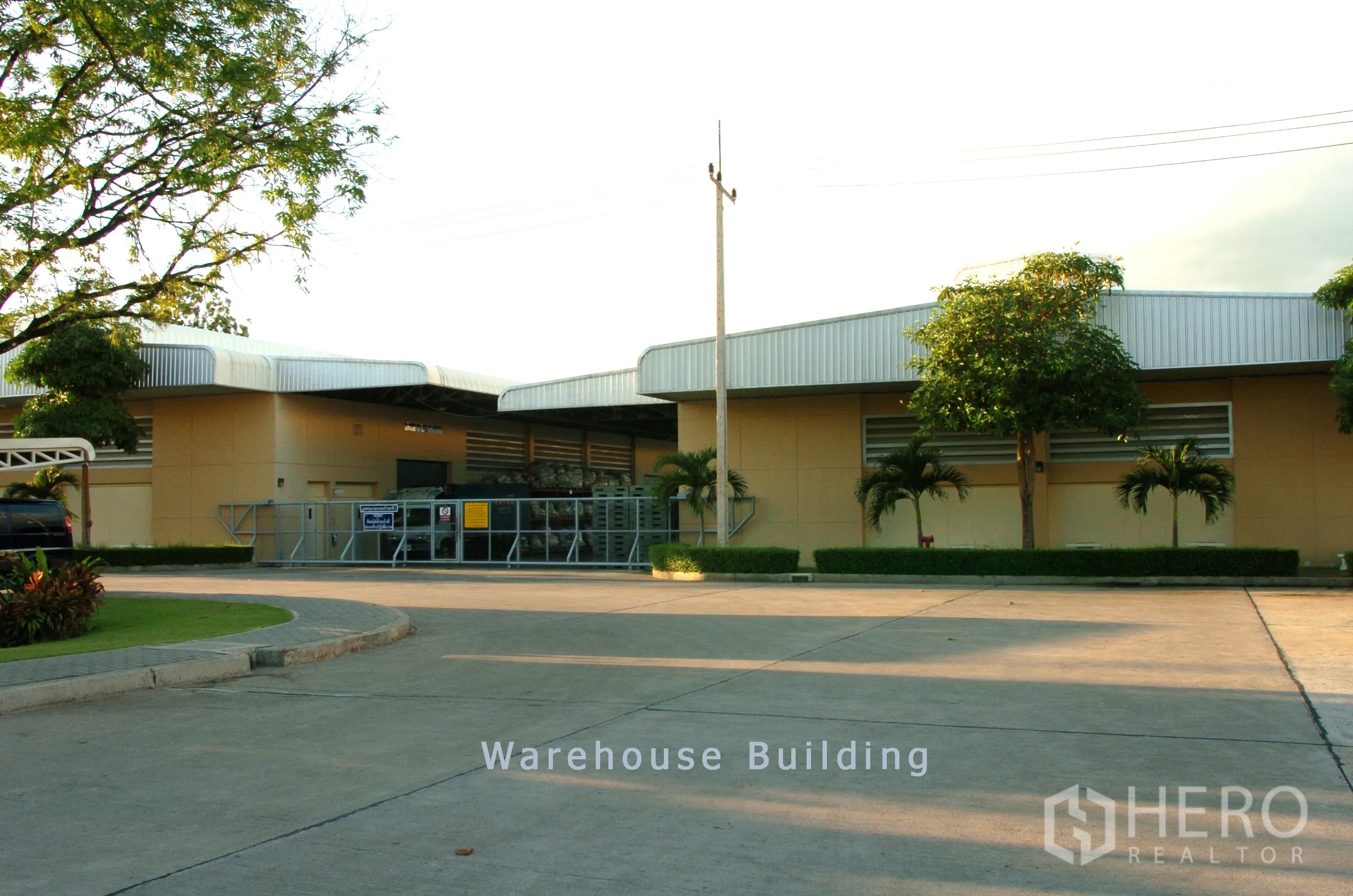 工厂 for sale in Khao Chamao, Rayong - 低层仓库建筑，金属屋顶，装卸区及宽阔车道，方便卡车进出。