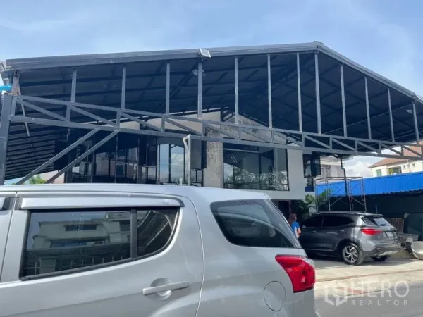 Home Office for rent in Wang Thonglang, Bangkok - Facade with high gable roof, glass walls and multiple cars in the driveway