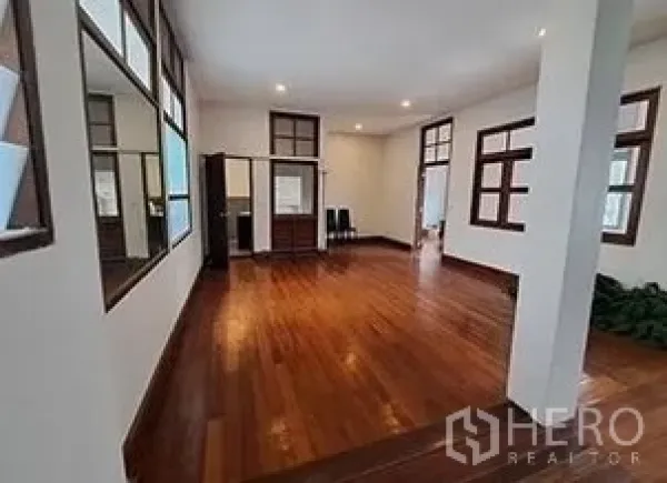 零售空间 出租在Bangkok - 宽敞展厅式房间，硬木地板、筒灯与多扇窗框。