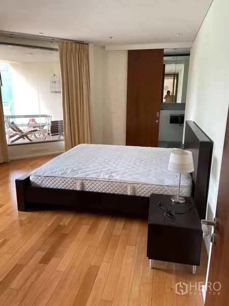 公寓 出租在Khlong Toei, Bangkok - 宽敞主卧，木地板，床头柜，可通往阳台。