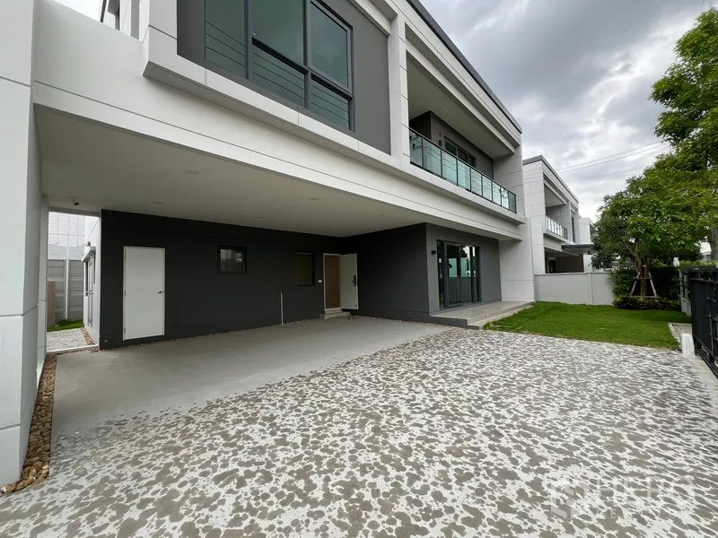 Detached House for rent or sale in Bang Phli, Samut Prakan - Covered carport and patterned driveway beside a small lawn and entry.