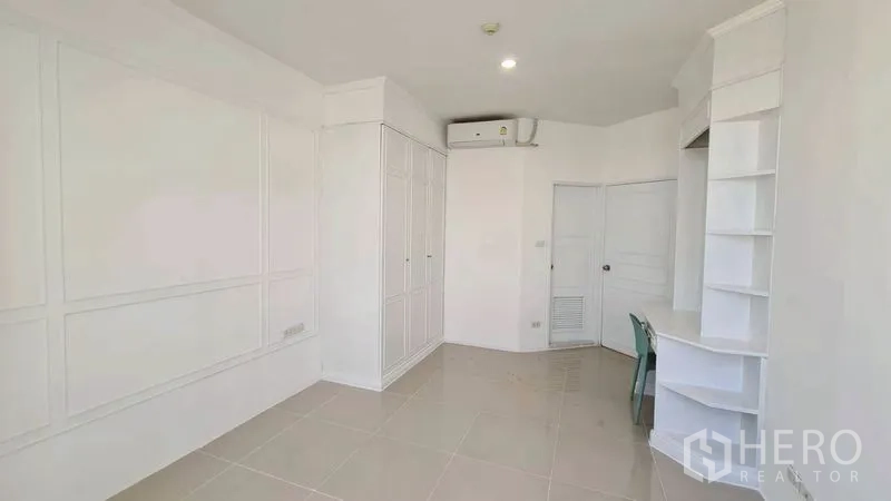 Condominium for rent in Watthana, Bangkok - Room with built-in wardrobe, desk, and air conditioner.