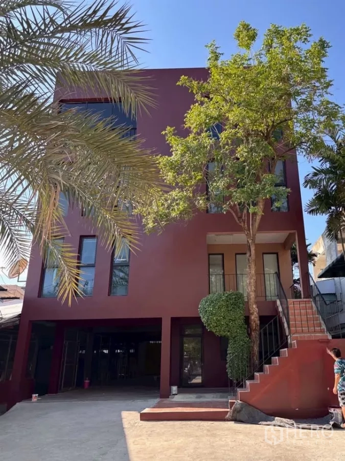 สำนักงานที่บ้าน ให้เช่าในPhra Khanong, Bangkok - อาคารโฮมออฟฟิศ 3 ชั้นสีแดงเข้ม บันไดทางขึ้นภายนอก หน้าบ้านมีที่จอดรถและต้นไม้ใหญ่ ย่านพระโขนง