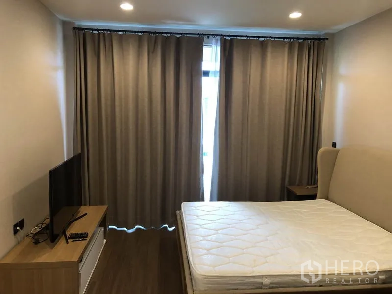 บ้าน ให้เช่าในBang Kapi, Bangkok - ห้องนอนมาสเตอร์ มีเตียง ตู้ทีวี และผ้าม่านทึบแสง