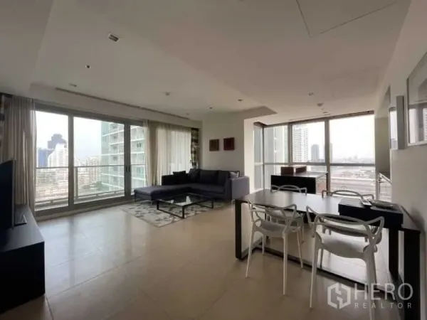 Condominium for rent or sale in Khlong San, Bangkok - Open-plan living and dining room with floor-to-ceiling windows and city view at The River condo.