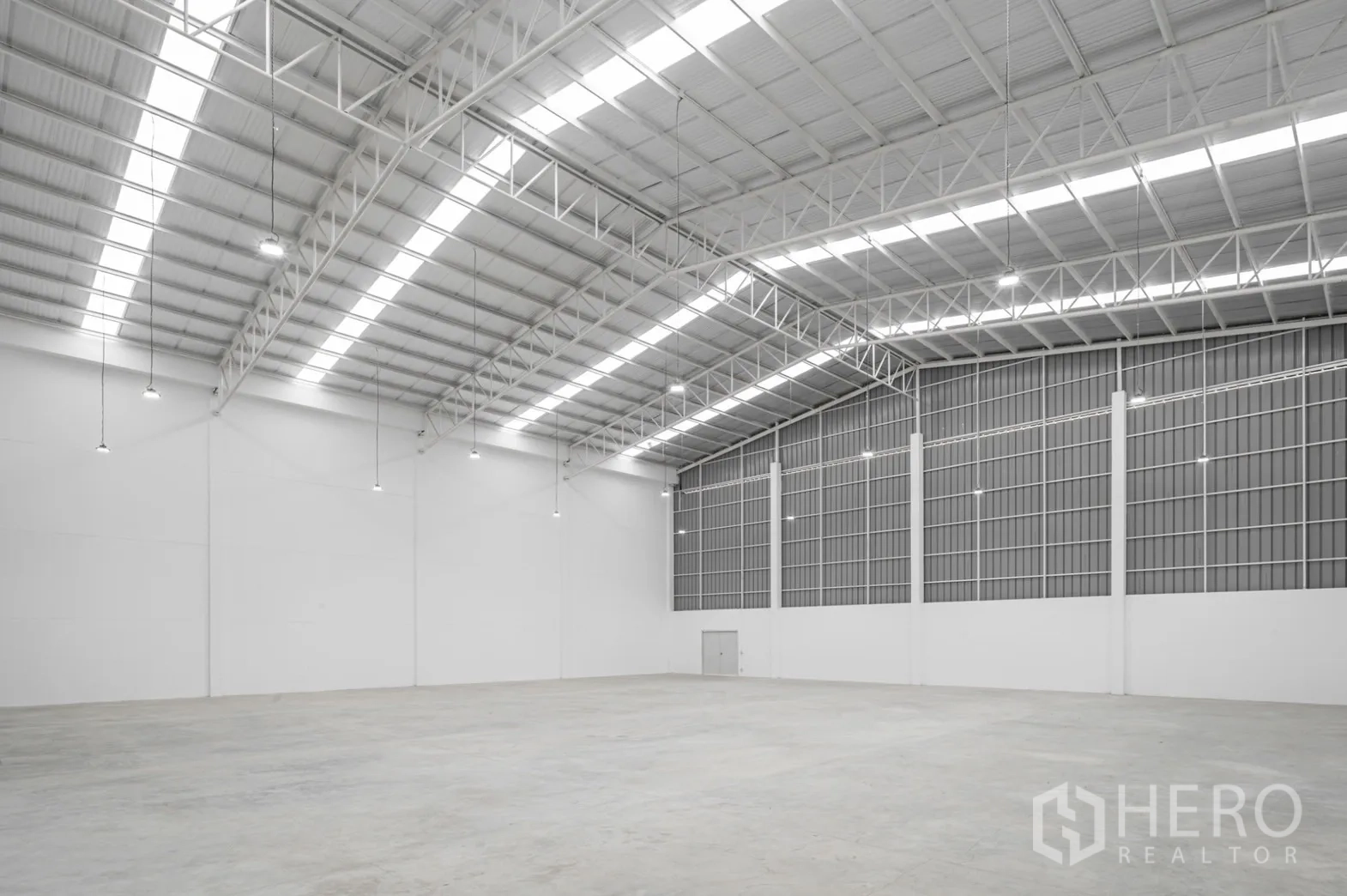 Factory for rent in Pathum Thani - Angled view of the high-bay warehouse showing skylights and steel trusses.
