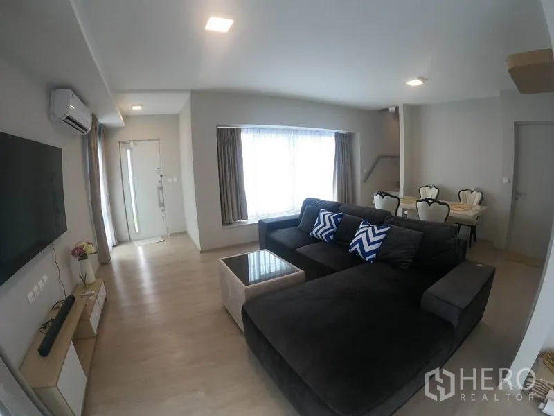 Detached House for rent in Prawet, Bangkok - Spacious living room view toward the entry hall, staircase and dining set.