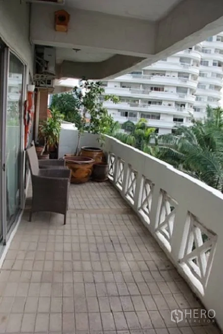 Condominium for sale in Wang Thonglang, Bangkok - Long covered balcony with outdoor chair and planters.