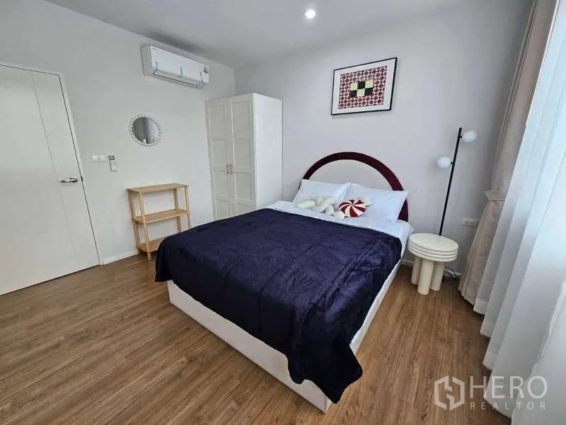 ทาวน์เฮาส์ ให้เช่าในSuan Luang, Bangkok - ห้องนอนพร้อมเตียงคู่ ตู้เสื้อผ้า งานศิลป์ติดผนัง และพื้นไม้