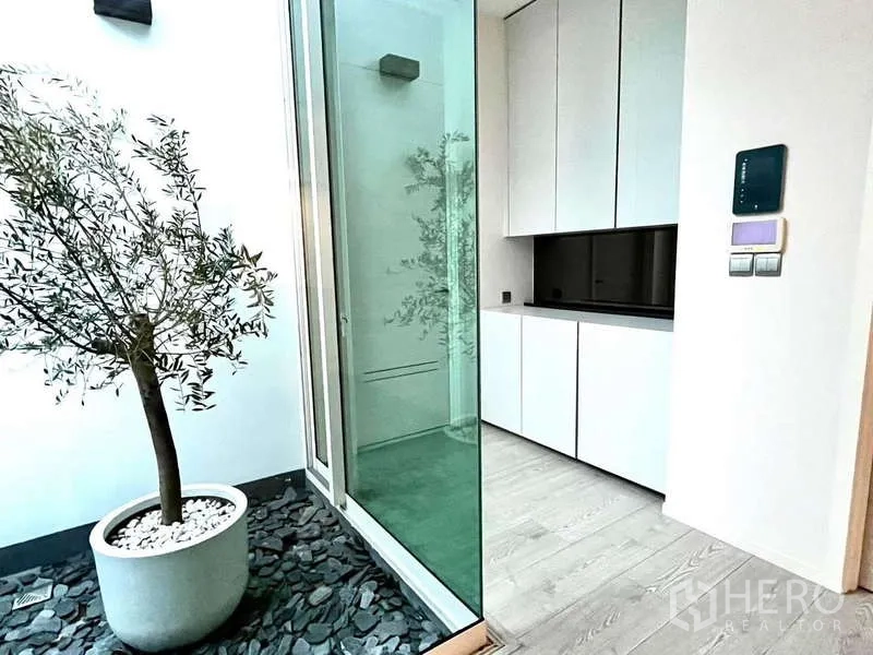 独立式住宅 出租或出售在Bang Phli, Samut Prakan - 室内小天井，盆栽树、碎石地与玻璃移门。