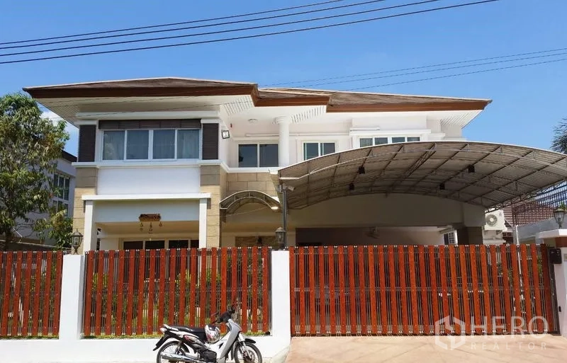 Detached House for sale in Suan Luang, Bangkok - Street-facing facade with red slat fence and expansive roofed carport.
