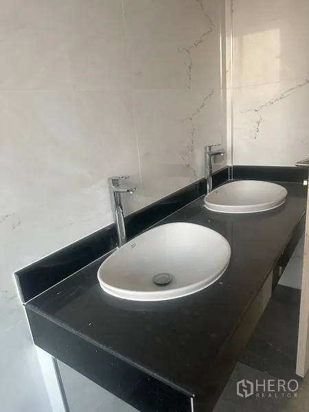店屋 出租在Watthana, Bangkok - 店屋内的现代卫浴，黑色石材台面上配置双台上盆。