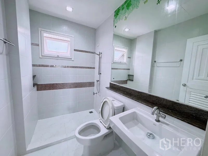 Detached House for rent in Prawet, Bangkok - Clean bathroom with walk-in shower, toilet, and long mirror.
