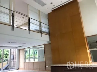 ทาวน์เฮาส์ ให้เช่าหรือขายในYan Nawa, Bangkok - ห้องนั่งเล่นเพดานสูงสองชั้น พร้อมชั้นลอยและผนังไม้เด่น