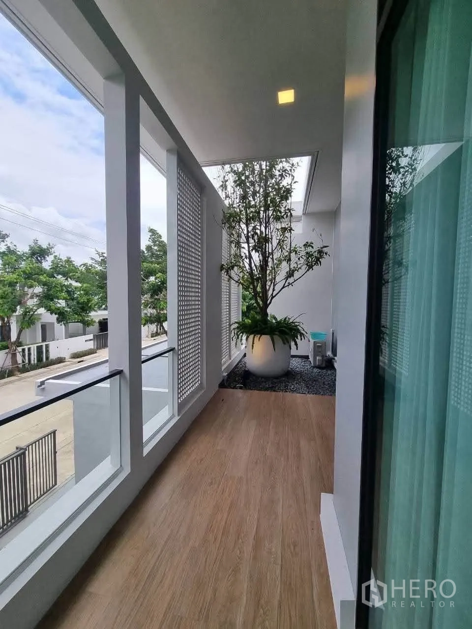 Detached House for rent in Bang Phli, Samut Prakan - Covered balcony corridor with planter and privacy screens overlooking the street.