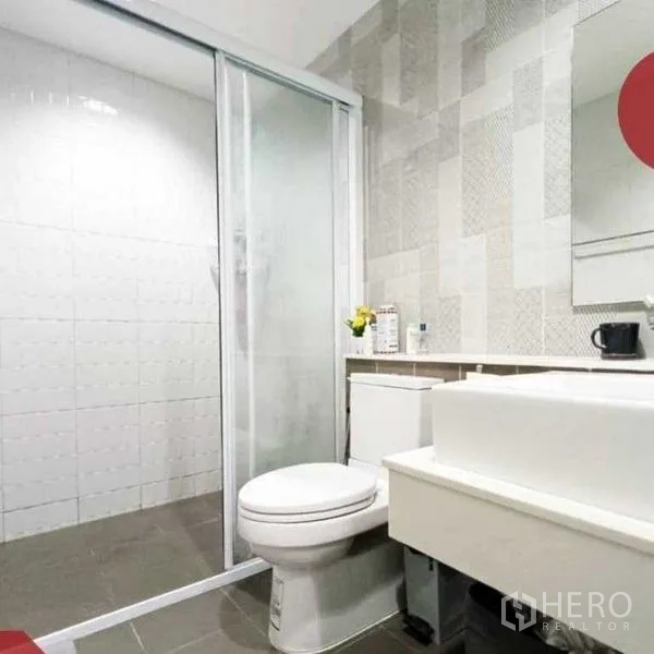 Home Office for rent or sale - Modern bathroom featuring a glass-enclosed shower, patterned wall tiles and a sleek vanity.