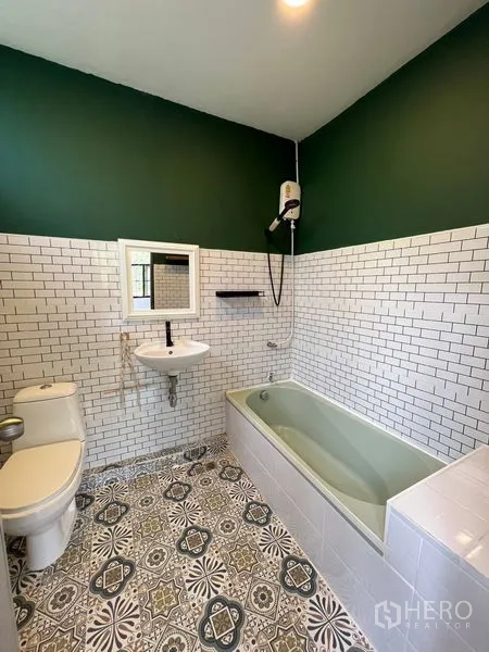 Townhouse for rent in Ratchathewi, Bangkok - Bathroom with green accent wall, white subway tiles, patterned floor and bathtub.