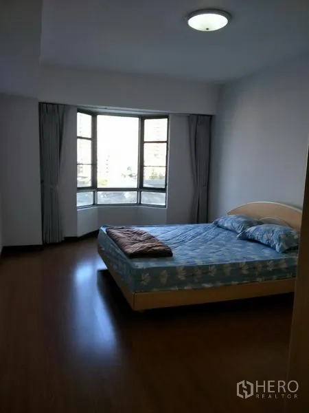 Condominium for rent in Watthana, Bangkok - Master bedroom with bay window, double bed, wood flooring, and city outlook.